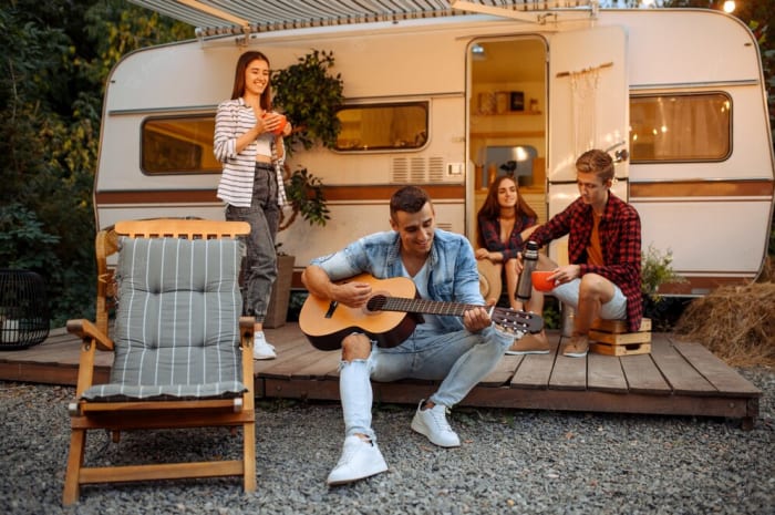 happy-friends-singing-songs-with-guitar-picnic-camping-forest-youth-with-summer-adventures-motorhome-campervan-two-couples-leisure-travel-with-caravan_266732-19725